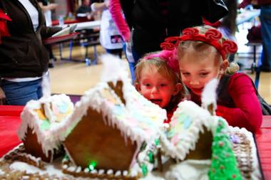 Addison Gerber, 2, reacts with excitement while checking out the gingerbread houses with her friend, Sohayla Henry, 4, right, at the “We Knead the Dough” festival at Faith Lutheran School campus Saturday, December 8, 2012.